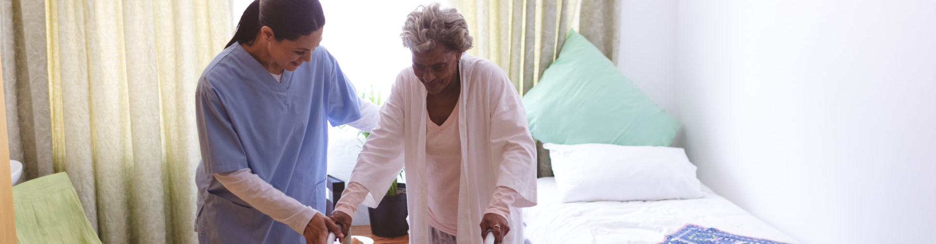 caregiver assisting elderly woman in walking